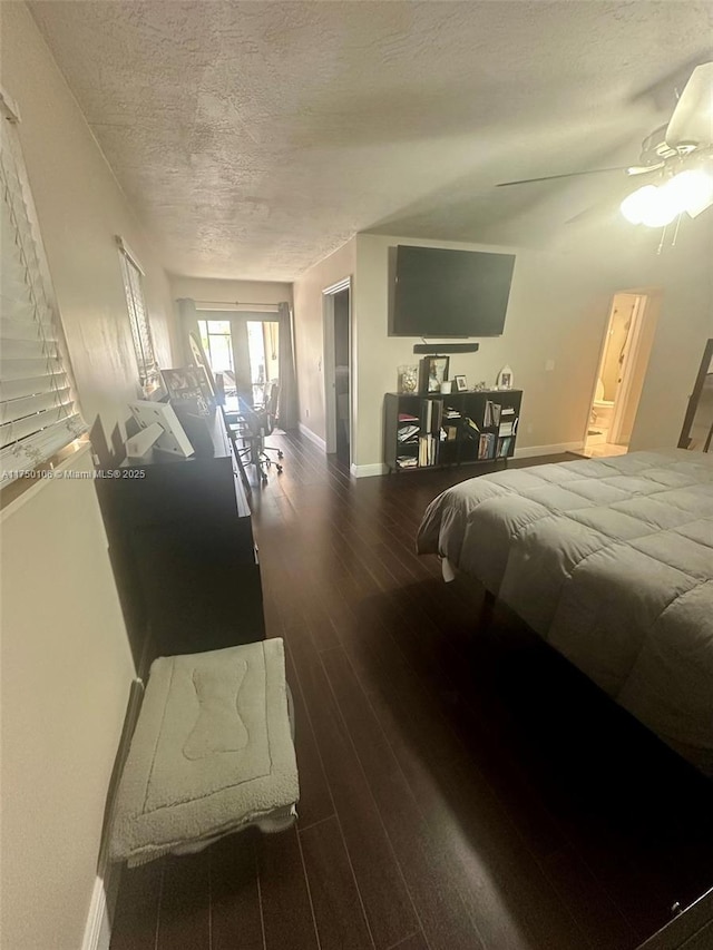 bedroom with baseboards, a ceiling fan, dark wood-style flooring, and a textured ceiling