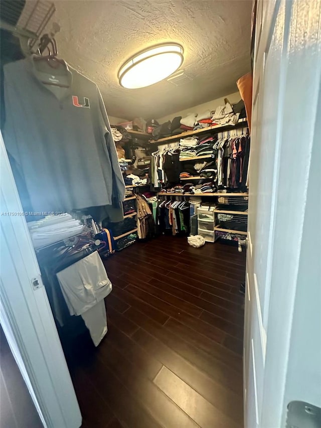 spacious closet with dark wood-style floors