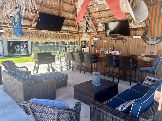 view of patio featuring an outdoor hangout area, fence, outdoor dry bar, and a gazebo