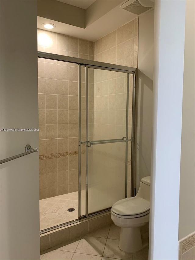 bathroom featuring toilet and a shower stall