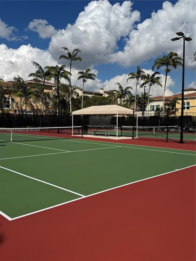 view of tennis court featuring fence