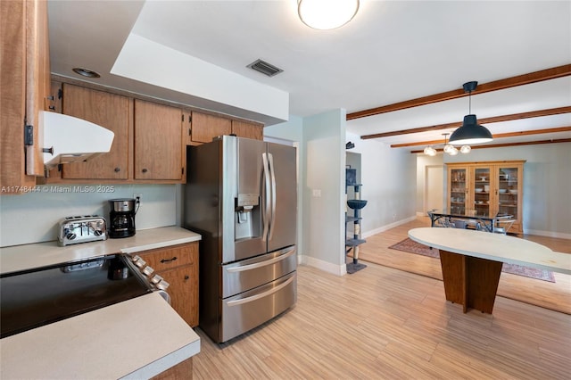 kitchen with under cabinet range hood, visible vents, light countertops, stainless steel refrigerator with ice dispenser, and pendant lighting