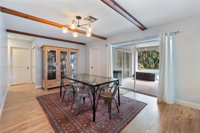 dining space with beam ceiling, light wood finished floors, visible vents, a chandelier, and baseboards