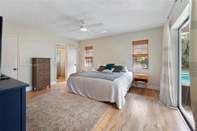 bedroom with ceiling fan, multiple windows, baseboards, and wood finished floors