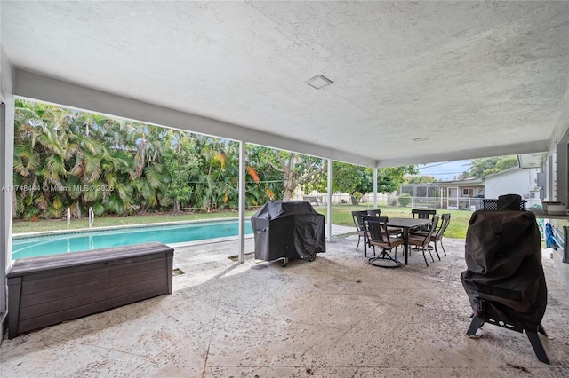 exterior space featuring outdoor dining area, area for grilling, fence, and a fenced in pool