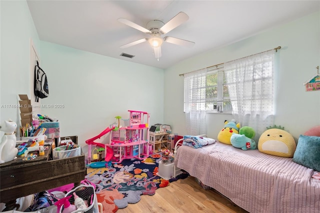 bedroom featuring ceiling fan, wood finished floors, and visible vents