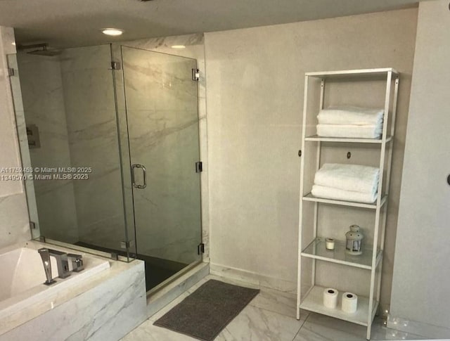 bathroom featuring a stall shower, marble finish floor, and a garden tub