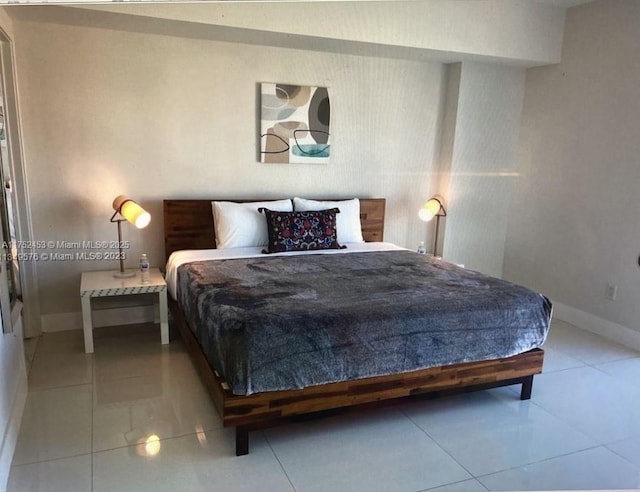 bedroom with baseboards and light tile patterned floors