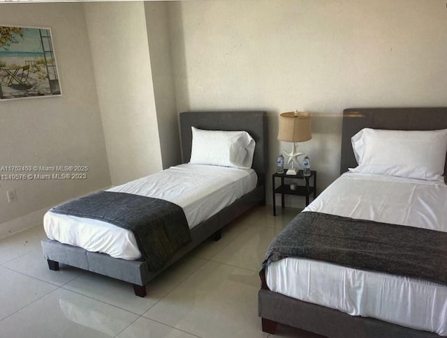 bedroom with light tile patterned flooring and baseboards