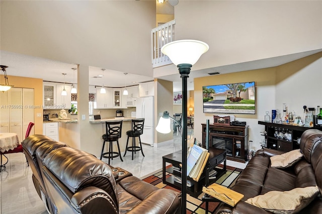 living room with a high ceiling and light tile patterned floors