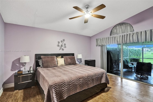 bedroom with lofted ceiling, a textured ceiling, dark wood-type flooring, baseboards, and access to outside