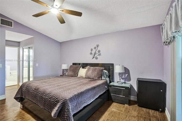 bedroom with baseboards, visible vents, lofted ceiling, wood finished floors, and a textured ceiling