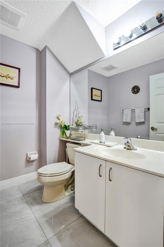 bathroom featuring visible vents, a textured ceiling, toilet, and vanity