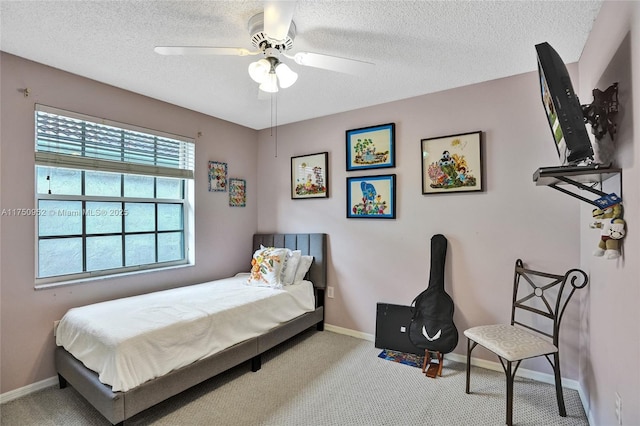 bedroom with a ceiling fan, carpet flooring, a textured ceiling, and baseboards