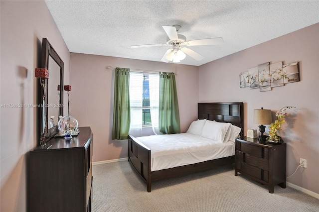 bedroom with a ceiling fan, light carpet, a textured ceiling, and baseboards