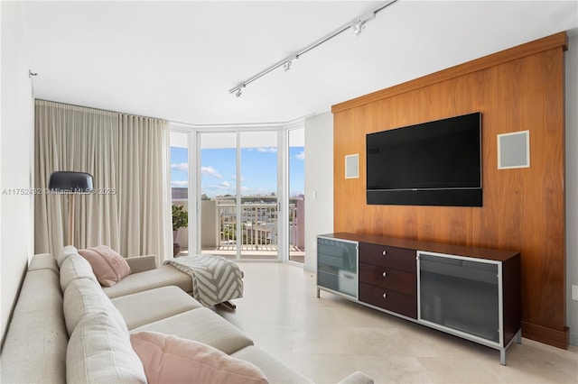 living area featuring expansive windows, rail lighting, and light tile patterned flooring