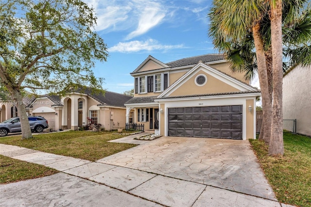 traditional-style house featuring driveway, a front lawn, a tile roof, and stucco siding