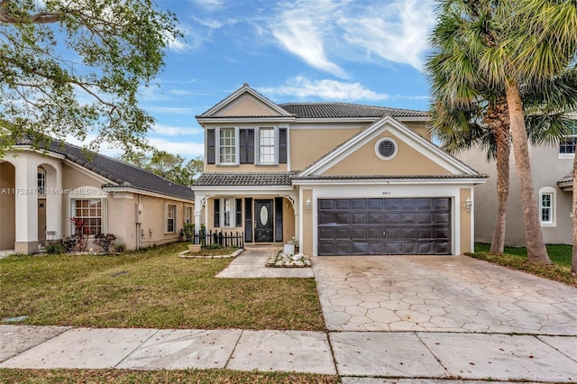 traditional-style home with an attached garage, a tile roof, driveway, stucco siding, and a front lawn