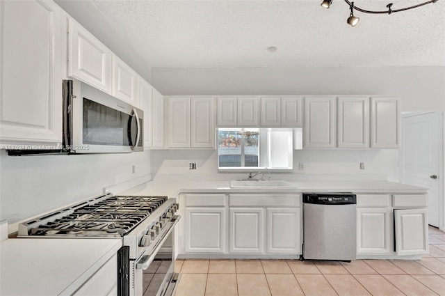 kitchen with light countertops, appliances with stainless steel finishes, a sink, and white cabinets