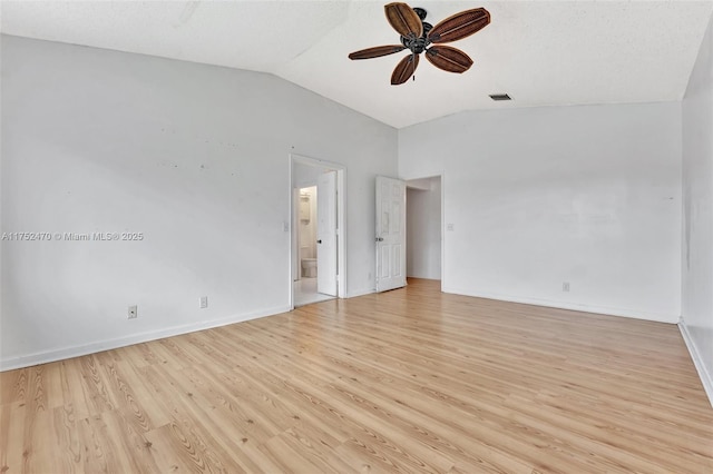 empty room with lofted ceiling, visible vents, baseboards, a ceiling fan, and light wood finished floors