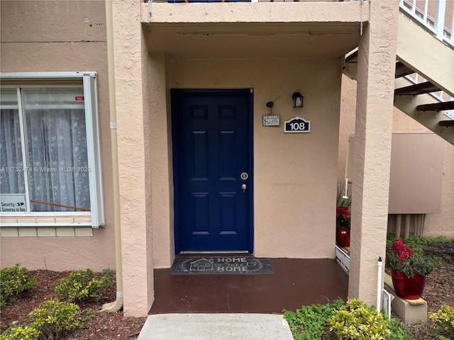 entrance to property featuring stucco siding