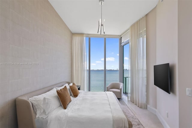 bedroom with expansive windows, light tile patterned floors, baseboards, and access to exterior