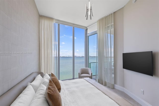 bedroom featuring baseboards, expansive windows, and access to exterior