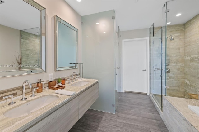 bathroom with double vanity, a stall shower, and a sink