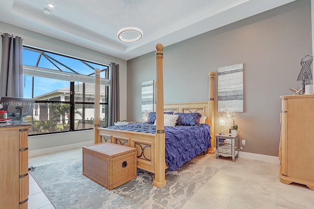 bedroom with baseboards and a raised ceiling