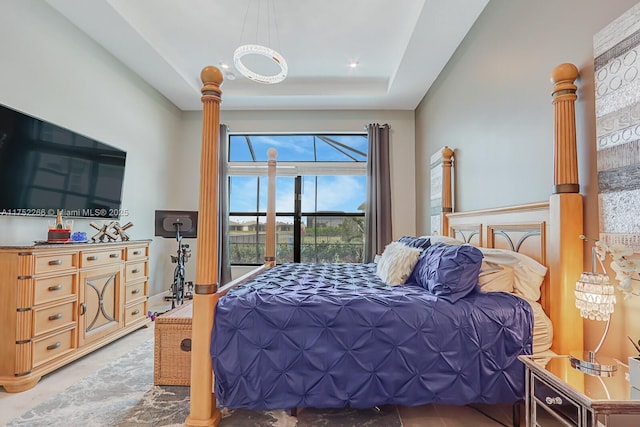 bedroom with ornate columns and a tray ceiling