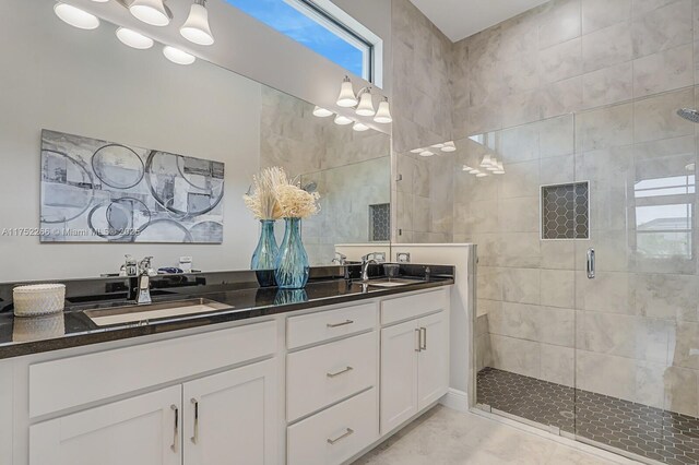 full bathroom featuring a stall shower, a sink, and double vanity