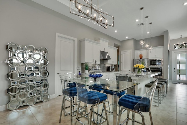 kitchen featuring a spacious island, visible vents, decorative backsplash, appliances with stainless steel finishes, and under cabinet range hood