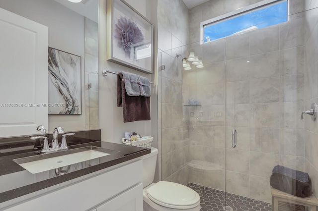 bathroom featuring toilet, a stall shower, and vanity