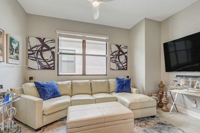 living area featuring ceiling fan and baseboards