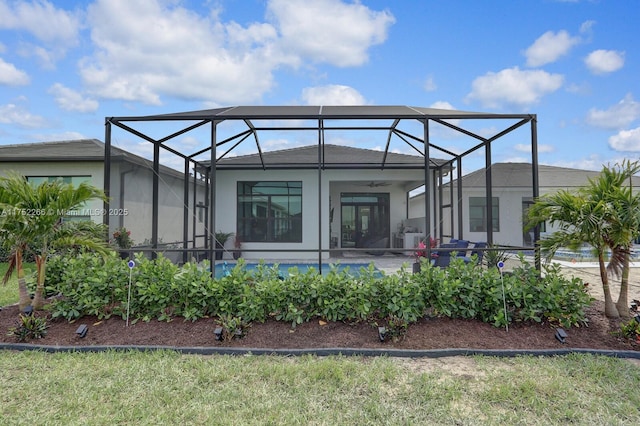 rear view of house featuring a lanai and ceiling fan