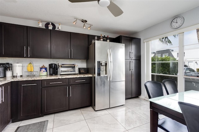 kitchen with stainless steel fridge, a toaster, backsplash, and dark brown cabinets