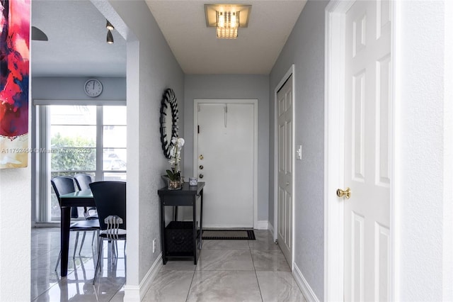 interior space featuring baseboards and a textured wall