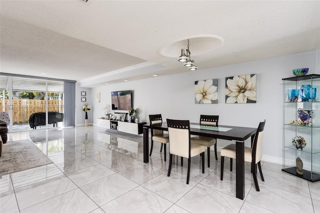 dining space with marble finish floor, a textured ceiling, and baseboards