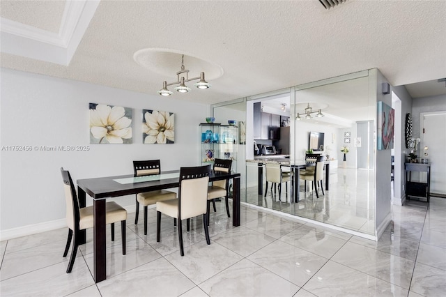 dining room with a textured ceiling, marble finish floor, a chandelier, and baseboards