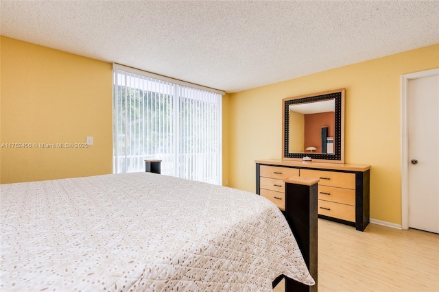 bedroom with a textured ceiling and light wood-style flooring