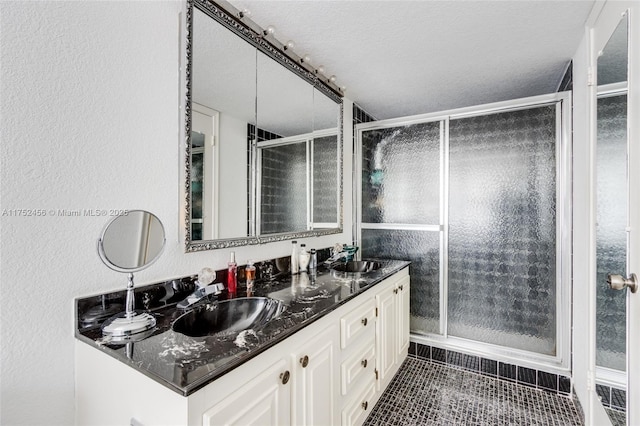 full bathroom with a stall shower, tile patterned flooring, a sink, and double vanity