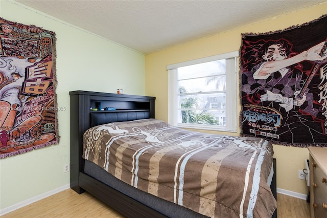 bedroom featuring a textured ceiling, vaulted ceiling, light wood-style flooring, and baseboards