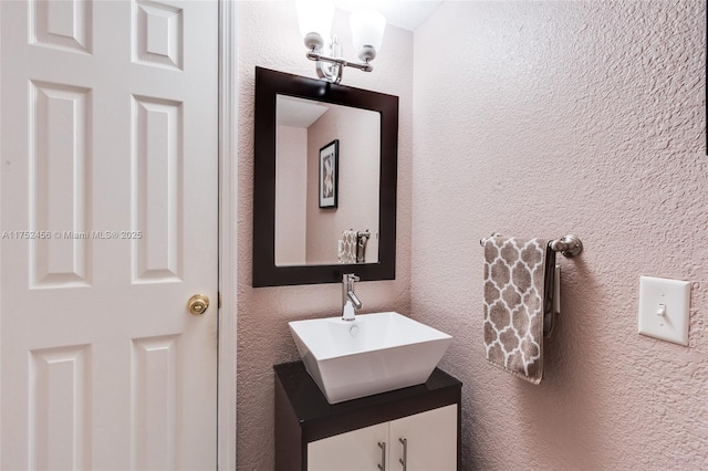 bathroom featuring a textured wall and vanity