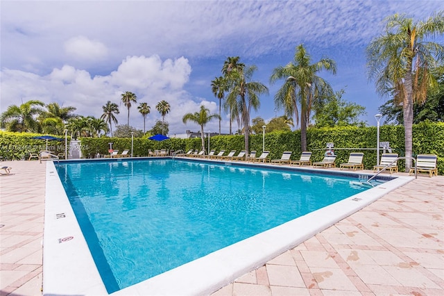 community pool with a patio and fence