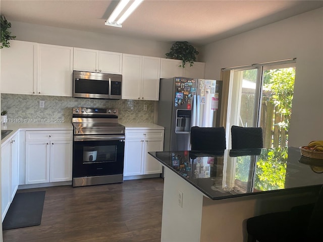 kitchen with dark wood-style floors, stainless steel appliances, backsplash, and white cabinets