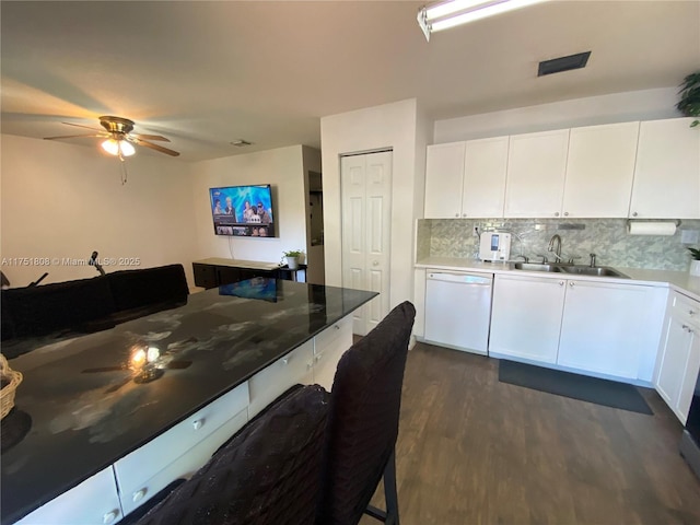 kitchen with a sink, white cabinets, dark wood-type flooring, and dishwasher