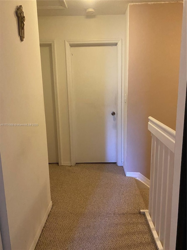 hallway with light carpet and baseboards