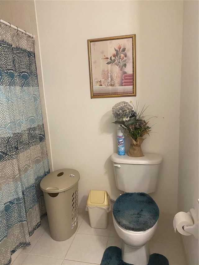 bathroom featuring tile patterned flooring, toilet, and a shower with curtain