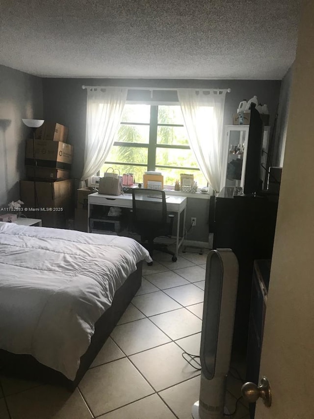 bedroom with light tile patterned floors and a textured ceiling