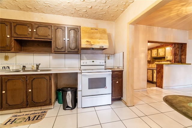 kitchen with light tile patterned flooring, a sink, light countertops, white electric range oven, and custom range hood